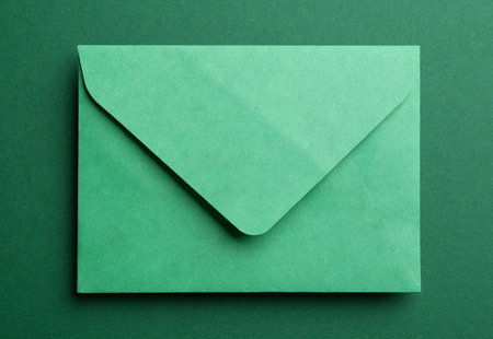 Paper envelope on green background, top viewの写真素材