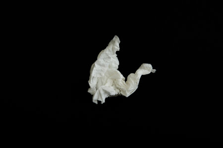 Used paper tissue on black background, top view