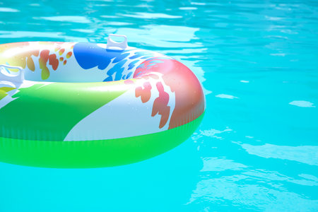 Inflatable ring in swimming pool on sunny day