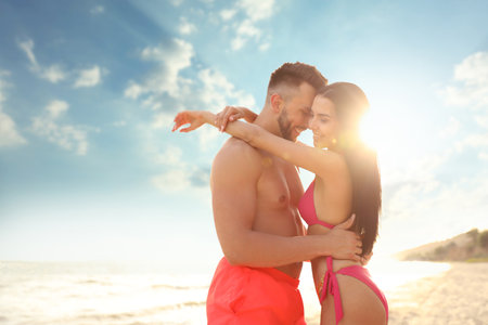 Happy young couple on beach on sunny dayの写真素材