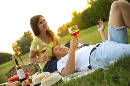 Happy couple having picnic in park on sunny dayの写真素材