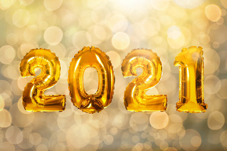 2021 New Year celebration. Bright gold balloons and blurred lights on backgroundの写真素材