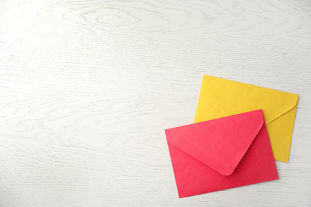 Paper envelopes on white wooden background, flat lay. Space for text