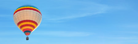 Hot air balloon in blue sky, space for text. banner design