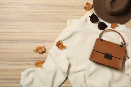 Flat lay composition with sweater and dry leaves on wooden background. autumn seasonの写真素材