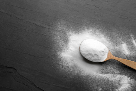 Baking soda on black table, top view. Space for textの写真素材