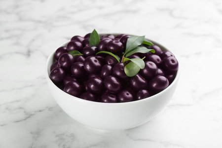 Fresh acai berries in bowl on white marble table, closeupの写真素材