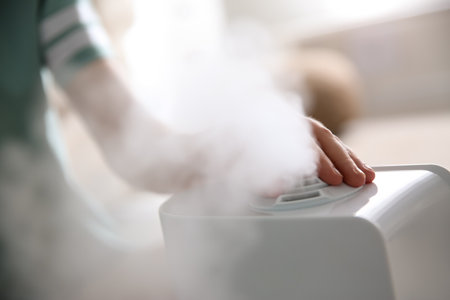 Woman using modern air humidifier at home, closeupの写真素材