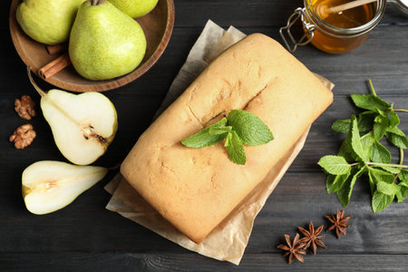 Flat lay composition with pear bread with mint on black wooden table. homemade cakeの写真素材