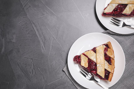 Slices of delicious fresh cherry pie served on grey table, flat lay. Space for textの写真素材