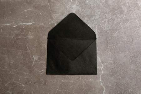 Black paper envelope on marble background, top viewの写真素材