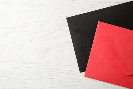 Paper envelopes on white wooden background, flat lay. Space for text
