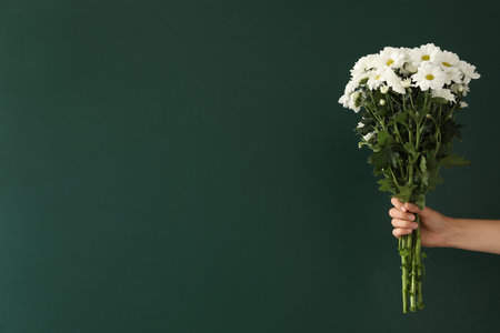 Woman holding beautiful bouquet near green chalkboard, space for text. Happy Teacher's Dayの写真素材