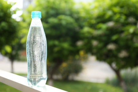 Plastic bottle of cold pure water outdoors. Space for textの写真素材
