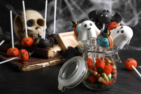 Different Halloween themed cake pops on black tableの写真素材