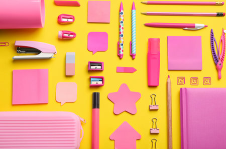 Flat lay composition with pink school stationery on yellow background. back to schoolの写真素材