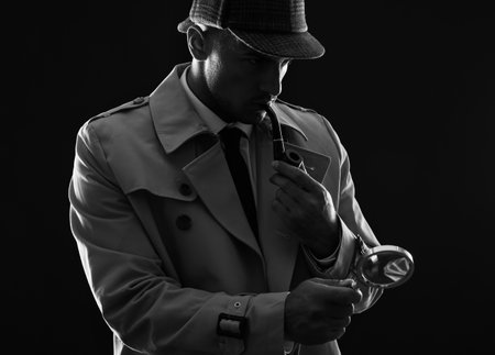 Old fashioned detective with magnifying glass smoking pipe on dark background, black and white effectの写真素材
