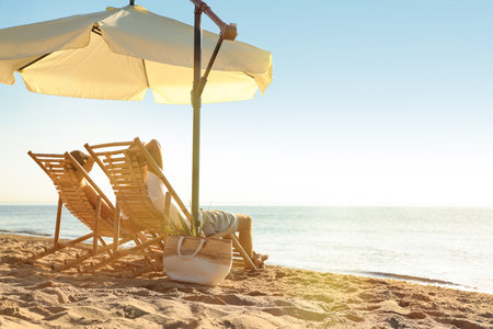 Couple relaxing on deck chairs at sandy beach. summer holidaysの写真素材
