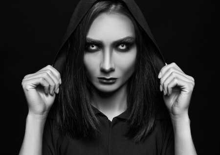Mysterious witch with spooky eyes on dark background. black and white effectの写真素材