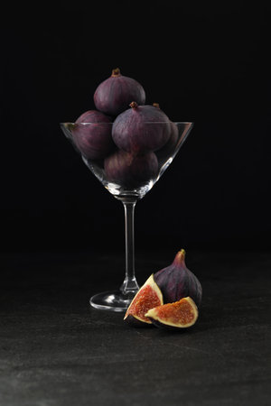 Tasty raw figs in martini glass on black tableの写真素材