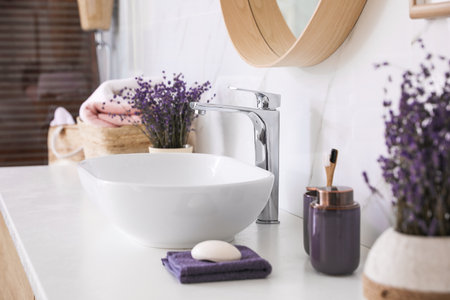 Bathroom counter with vessel sink, accessories and flowers. interior designの写真素材