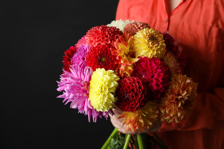 Woman with bouquet of beautiful dahlia flowers on black background, closeupの写真素材