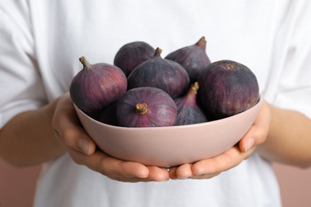 Woman holding bowl with tasty raw figs, closeupの写真素材