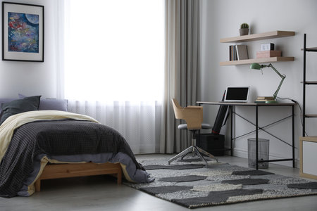 Modern teenager's room interior with workplace and bedの写真素材
