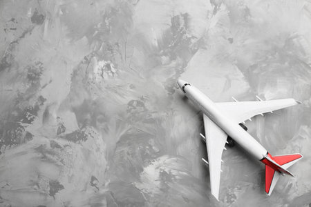 Toy airplane on gray background, top view. Space for text
