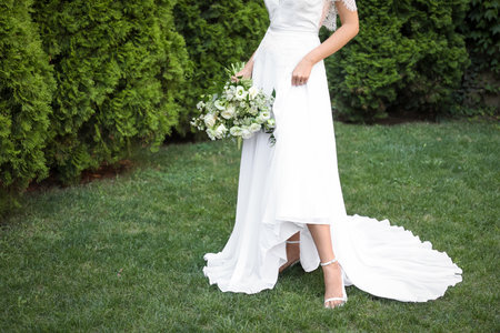 Bride in beautiful wedding dress with bouquet outdoors, closeupの写真素材