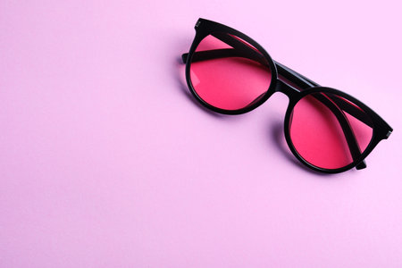 Stylish sunglasses on light violet background, top view. Space for textの写真素材