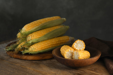 Tasty sweet corn cobs on wooden tableの素材 [FY310198302378]