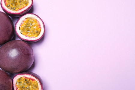 Fresh ripe passion fruits (maracuyas) on light pink background, flat lay. Space for textの写真素材
