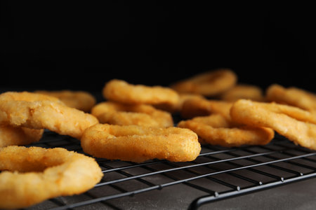 Cooling rack with fried onion rings on gray table, closeupの写真素材