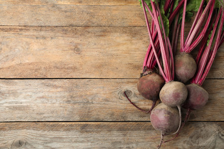 Raw ripe beets on wooden table, flat lay. Space for textの写真素材