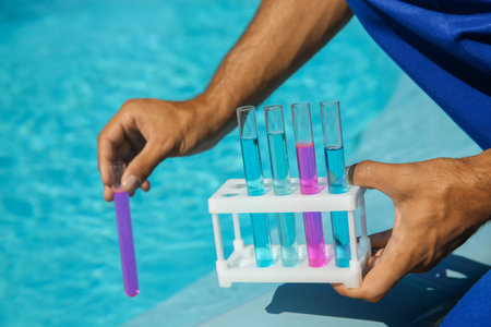 Man holding test tubes with reagents near swimming pool, closeupの写真素材