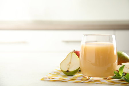 Tasty pear juice and cut fruit on white table, closeup. Space for textの写真素材