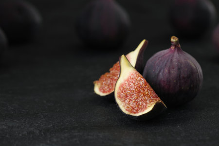 Tasty raw figs on black slate table, closeup. Space for textの写真素材