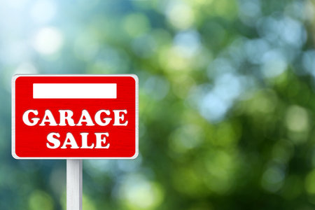 Sign with phrase GARAGE SALE on blurred green background, bokeh effectの写真素材