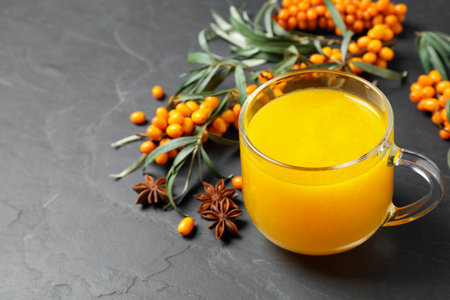 Sea buckthorn tea and fresh berries on gray tableの写真素材