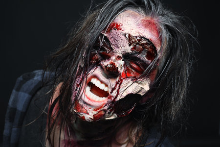 Scary zombie on dark background, closeup. Halloween monster