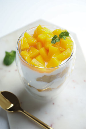 Tasty peach dessert with yogurt served on white tableの写真素材