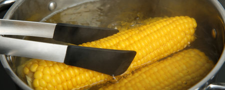 Taking fresh corn cob from pot with hot water on stove, banner design