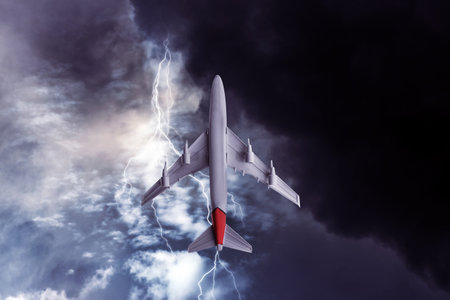Airplane flying in cloudy sky during thunderstormの写真素材