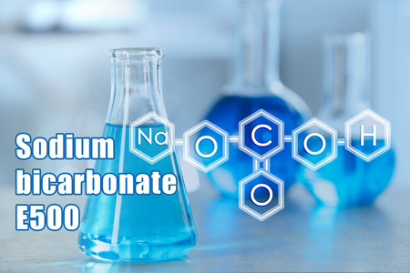 Text Sodium bicarbonate E500 with soda formula and laboratory glassware on backgroundの写真素材