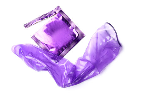 Unrolled violet condom and package on white background. safe sexの写真素材