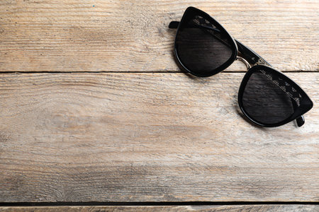 Stylish sunglasses on wooden background, top view. Space for textの写真素材
