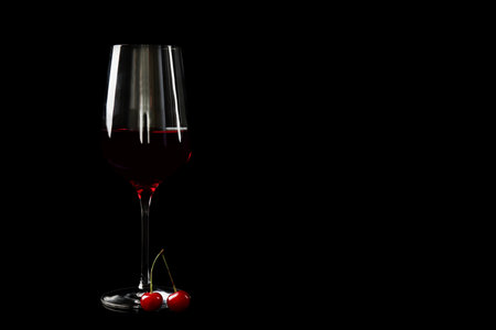 Delicious cherry wine with ripe juicy berries on black background. Space for textの写真素材