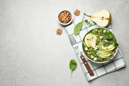 Tasty salad with pear slices served on light gray table, flat lay. Space for textの写真素材