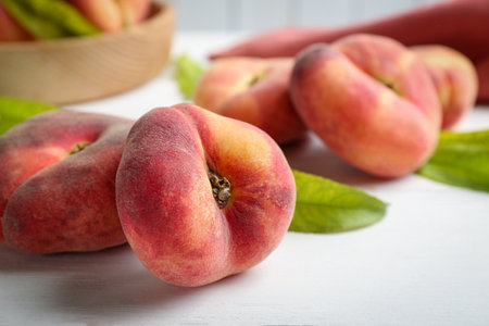 Fresh ripe donut peaches on white wooden table, closeupの写真素材